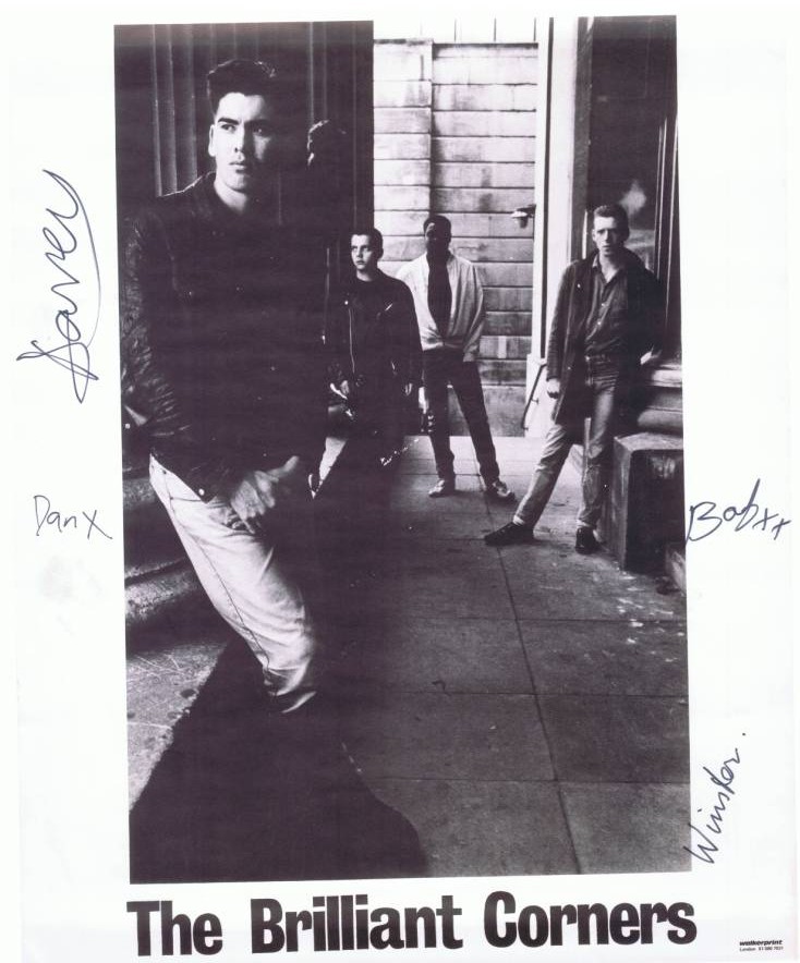 A group of people standing on a sidewalk

Description automatically generated
