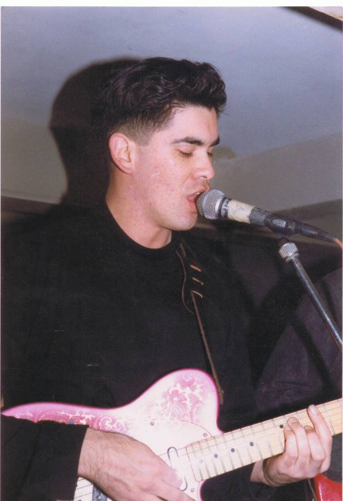 A person holding a guitar

Description automatically generated