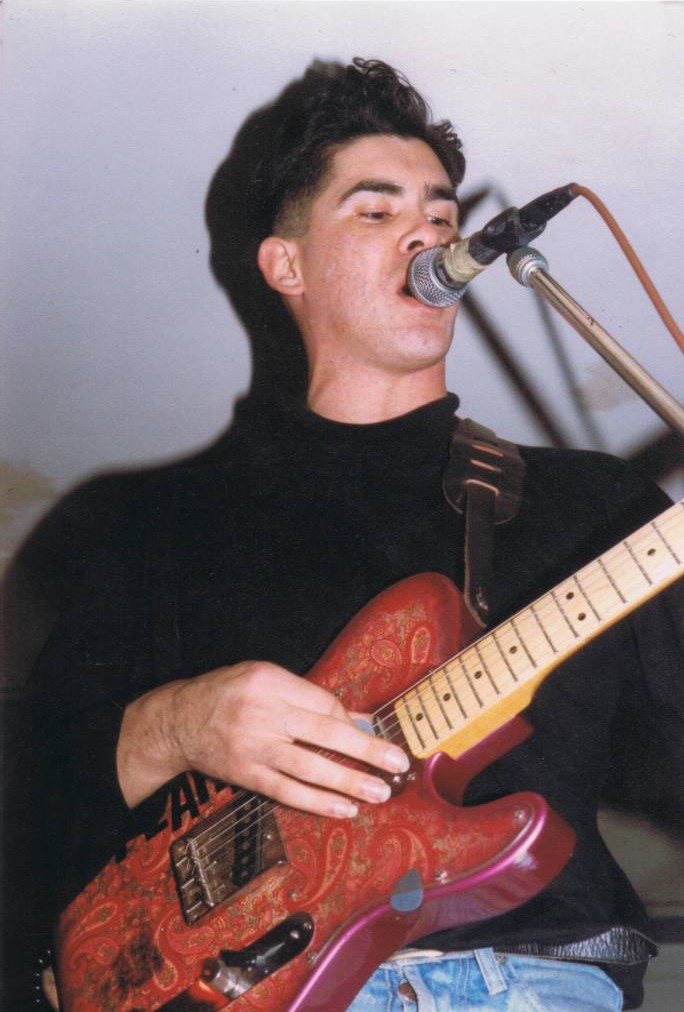 A person holding a guitar

Description automatically generated